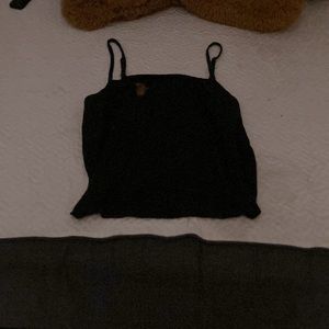 I am selling a black tank top with a red spot on it on top